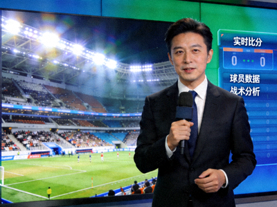记者正在报道体育新闻，背景是体育场馆与数据分析屏幕